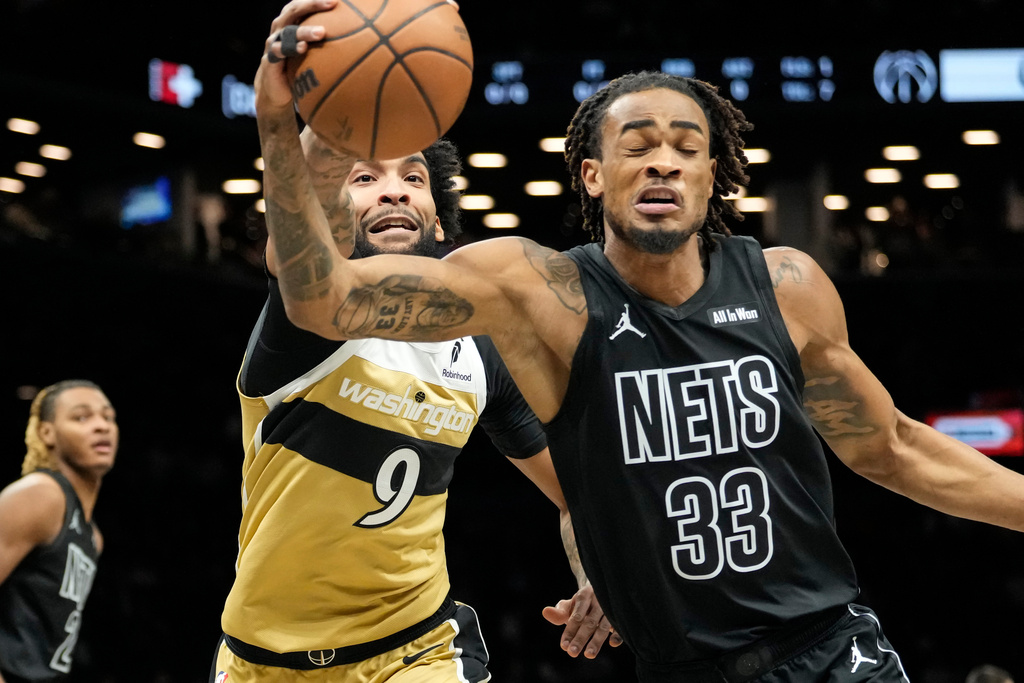 Brooklyn Nets center Nic Claxton (33) fights for control of the ball with Washington Wizards forward Justin Champagnie (9) during the first half of an NBA basketball game, Saturday, Feb. 7, 2026, in New York. (AP Photo/Yuki Iwamura)