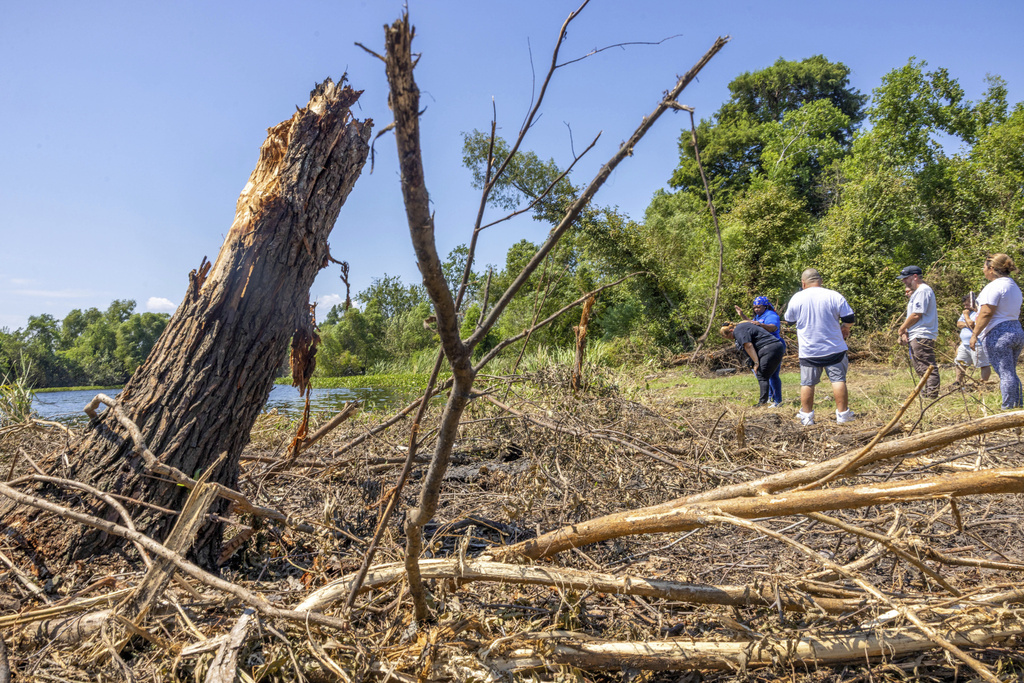 Friends, neighbors, and volunteers gather to pray and console each other near where 12-year-old Bryan Vasquez was found dead in a canal, left, on Tuesday, Aug. 26, 2025, in New Orleans East. (Chris Granger/The Times-Picayune/The New Orleans Advocate via AP)