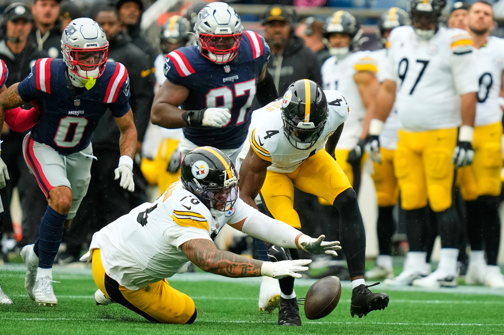 Pittsburgh Steelers' Troy Fautanu (76) and DK Metcalf (4) recover the ball after quarterback Aaron Rodgers was sacked during the first half of an NFL football game against the New England Patriots, Sunday, Sept. 20, 2026, in Foxboro, Mass. (AP Photo/Charles Krupa)