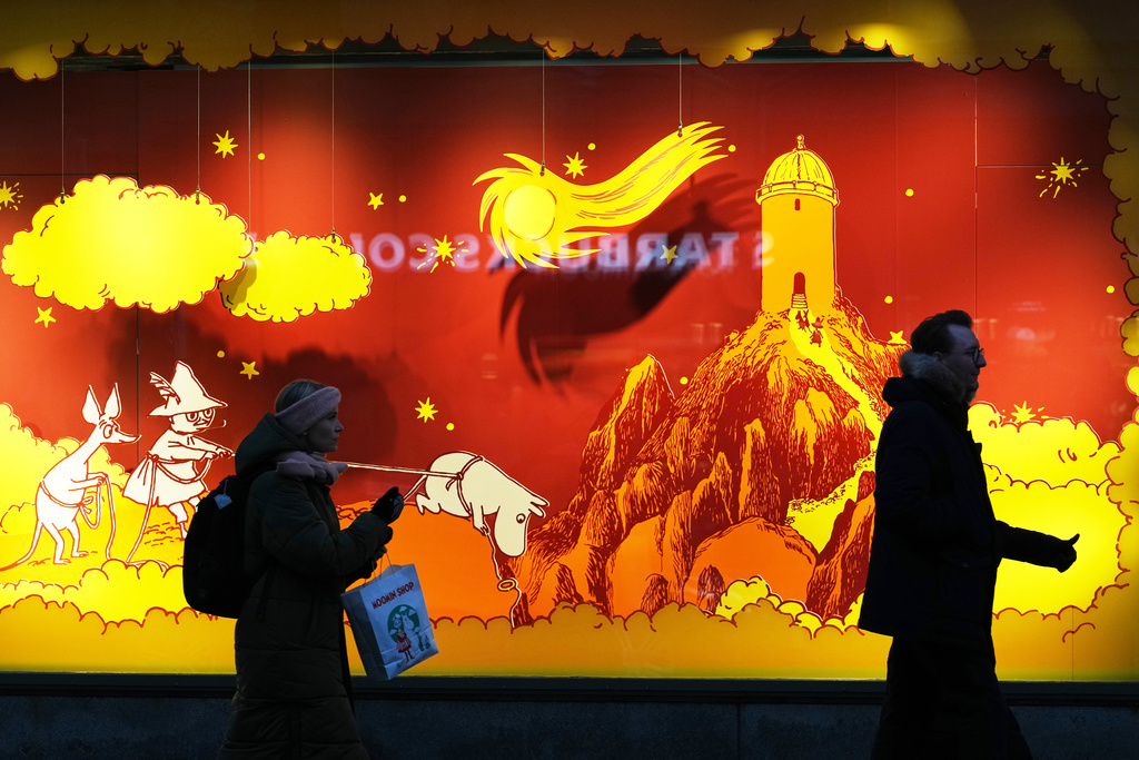 People pass a shop window in Helsinki, Finland, Friday, Nov. 14, 2025. (AP Photo/Sergei Grits)