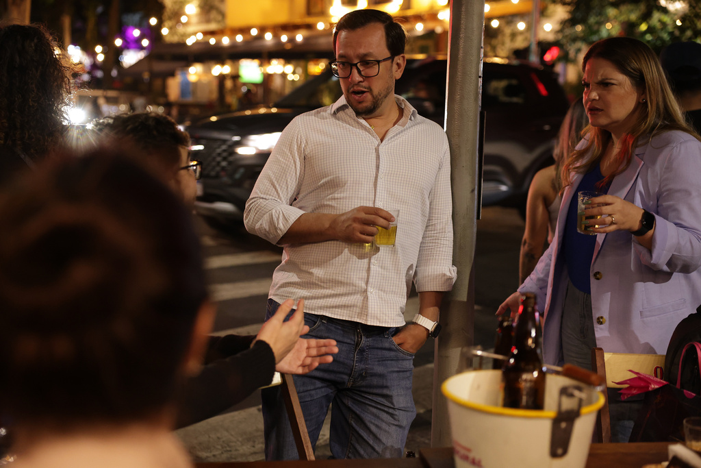 People drink beer at a bar in Sao Paulo, Friday, Oct. 3, 2025. (AP Photo/Ettore Chiereguini)