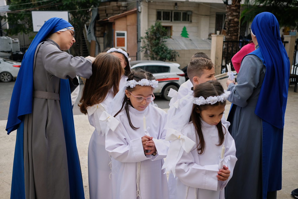 Children and nuns gather outside the Holy Family Catholic Church before attending a mass ahead of Christmas celebrations in Gaza City, Sunday, Dec. 21, 2025. (AP Photo/Jehad Alshrafi)