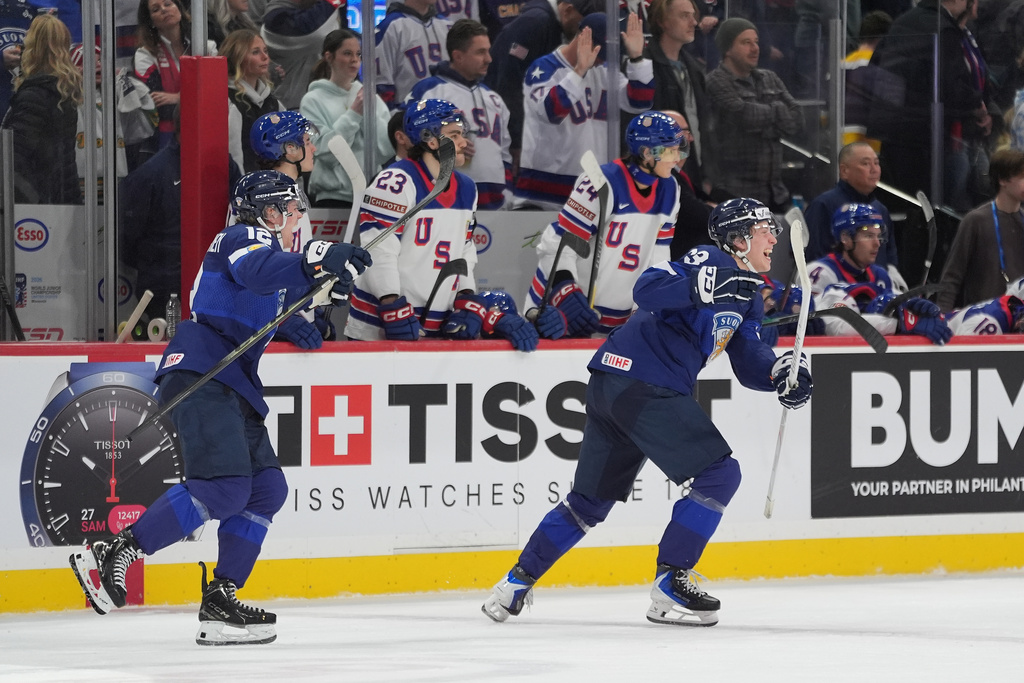 Finland forwards Joona Saarelainen (12), left, and forward Leo Tuuva (23) celebrate after the overtime win against the United States of an IIHF World Junior Hockey Championship quarterfinals game, Friday, Jan. 2, 2026, in St. Paul, Minn. (AP Photo/Abbie Parr)