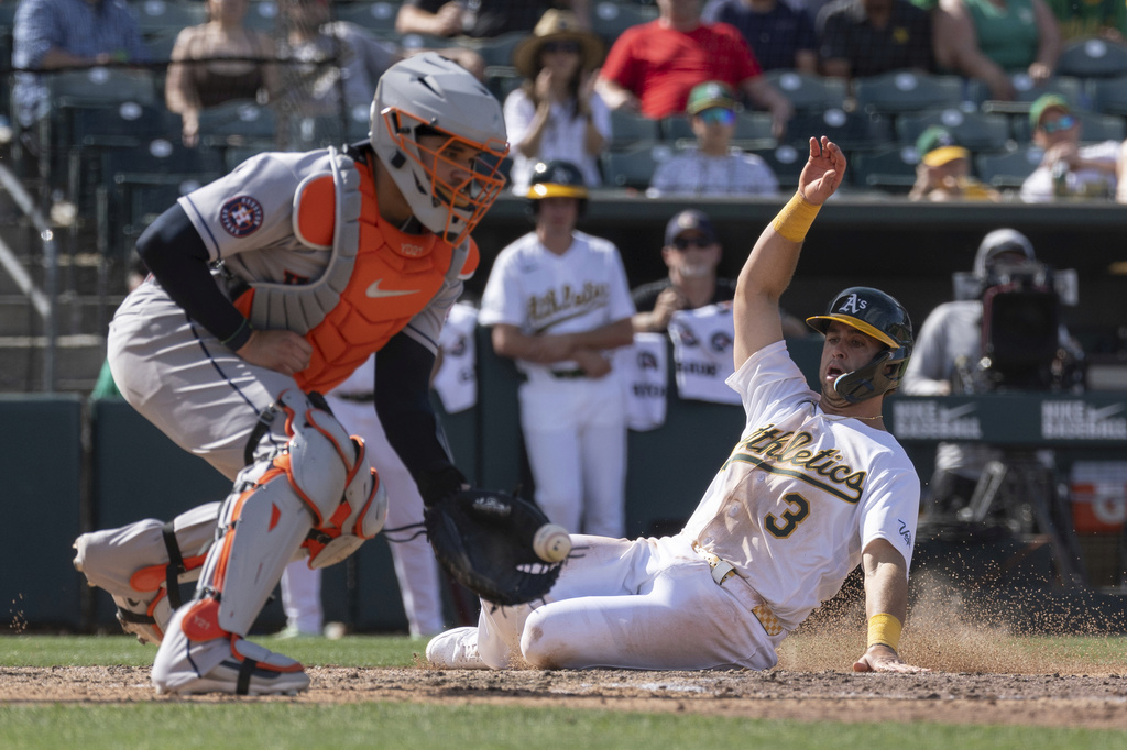 Houston Astros catcher Yainer Diaz (21) attempts to get Athletics' Max Muncy (3) out at home during the seventh inning of a baseball game Sunday, April 5, 2026, in West Sacramento, Calif. (AP Photo/Sara Nevis)