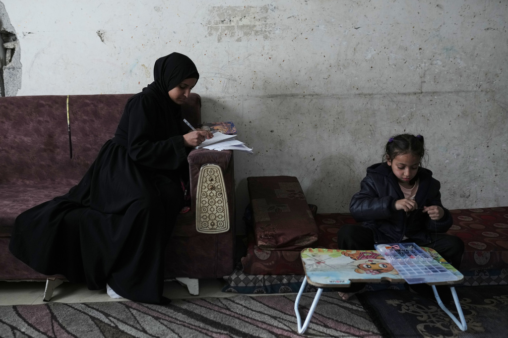 Raghad Ramzi Al-Ajal, who lost her parents in an Israeli airstrike, studies at the Gaza City home where she lives with relatives, Monday, Jan. 19, 2026. (AP Photo/Jehad Alshrafi)