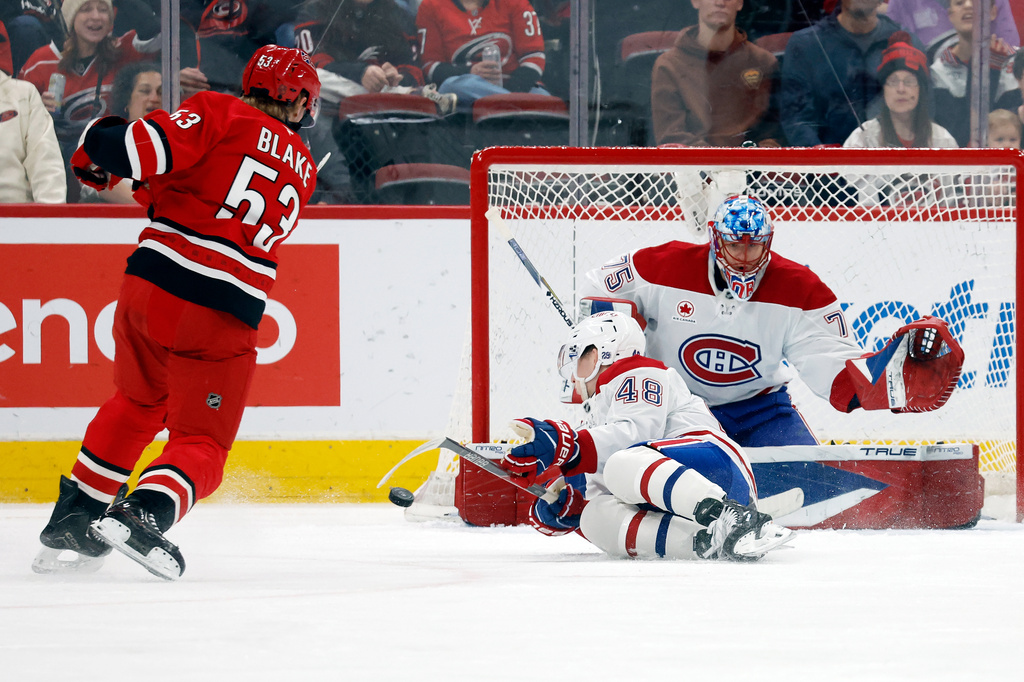 Carolina Hurricanes' Jackson Blake (53) shoots the puck off Montréal Canadiens' Lane Hutson (48) and wide of goaltender Jakub Dobes (75) during the first period of an NHL hockey game in Raleigh, N.C., Sunday, March 29, 2026. (AP Photo/Karl DeBlaker)