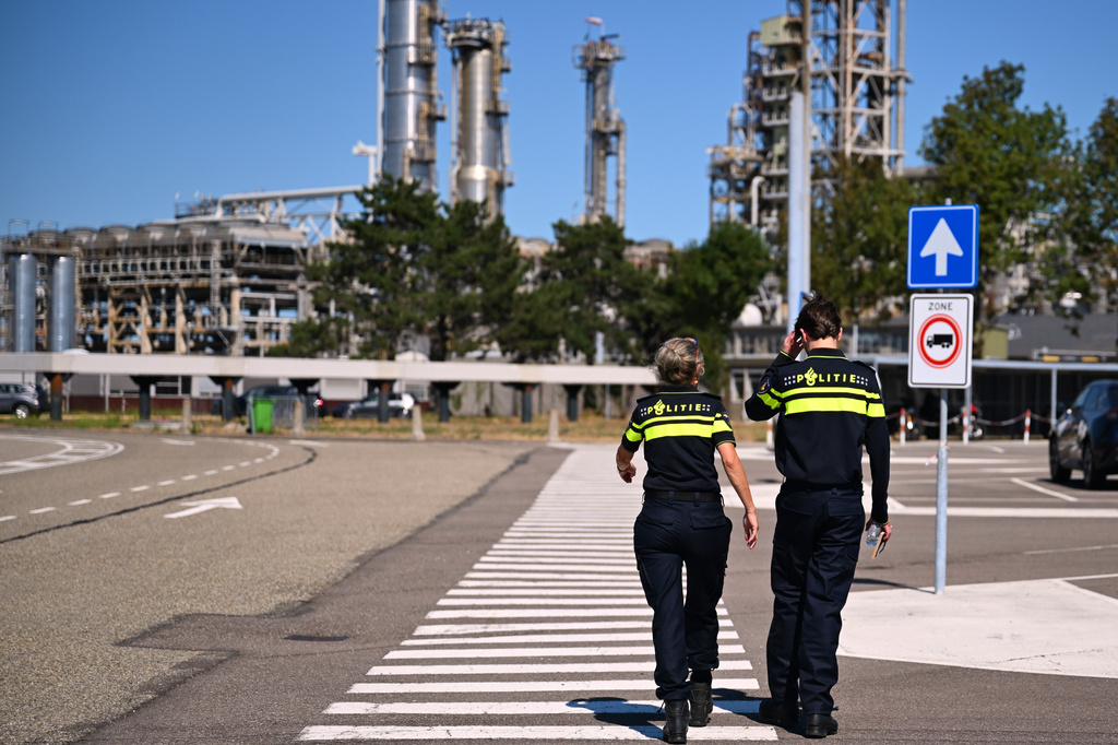 Police officers walk to a refinery and fuel terminal run by Gunvor Energy after an explosion at the Dutch port of Rotterdam which killed at least one person and injured several others according to police, in Rotterdam, Netherlands, Thursday, Aug. 13, 2026. (AP Photo/Mouneb Taim)