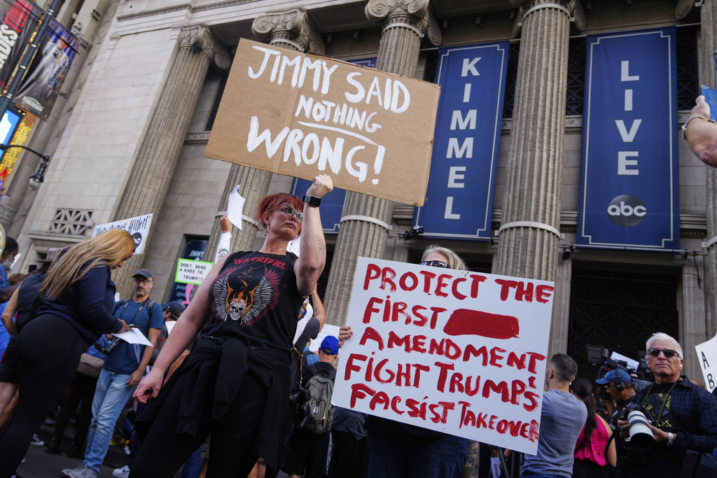 Demonstrators hold signs outside El Capitan Entertainment Centre, where the late-night show "Jimmy Kimmel Live!" is staged, Thursday, Sept. 18, 2025, in Los Angeles. (AP Photo/Damian Dovarganes)