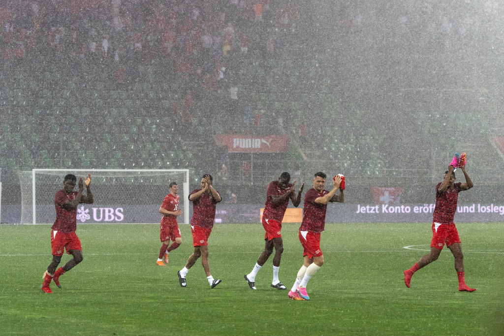 Players under poruing rain during the international friendly soccer match between Switzerland and Jordan in St. Gallen, Switzerland, Sunday, May 31, 2026. (Peter Schneider/Keystone via AP)