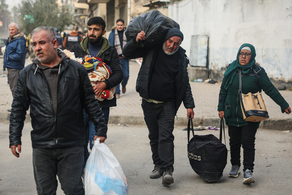 Residents flee the Sheikh Maqsoud and Achrafieh neighbourhoods after clashes erupted Tuesday between Syrian government forces and Kurdish fighters in a contested area of the northern city of Aleppo, Syria, Thursday, Jan. 8, 2026. (AP Photo/Ghaith Alsayed)