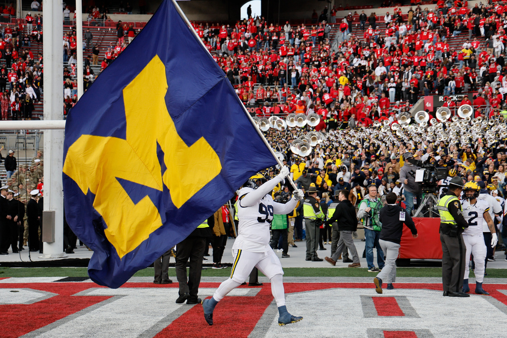FILE - Michigan defensive lineman Cam Goode waves a Michigan flag after their win over Ohio State in an NCAA college football game ,Nov. 26, 2022, in Columbus, Ohio. (AP Photo/Jay LaPrete, File)