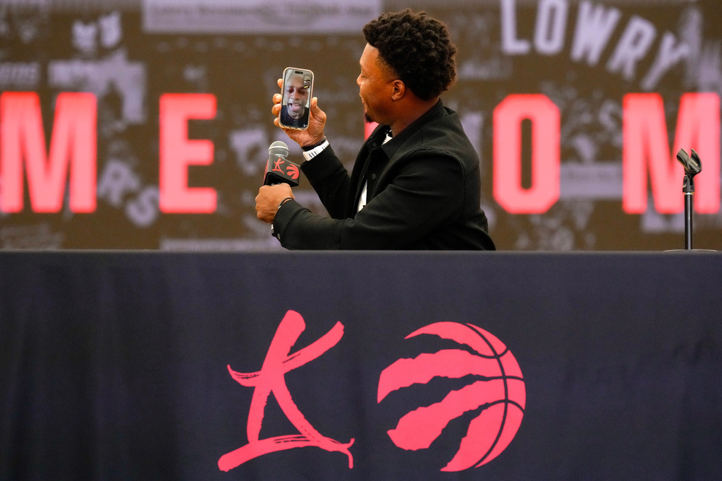 Kyle Lowry takes a face time call from Vince Carter at a press conference as he signs a one-day contract to retire as a Toronto Raptor, in Toronto, on Tuesday, July 7, 2026. (Chris Young/The Canadian Press via AP)
