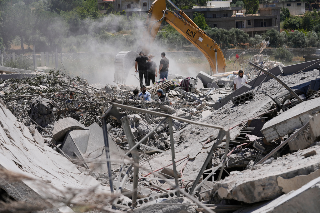 People who returned to their village following the announcement of an initial ceasefire agreement between the United States and Iran, use an excavator as they search for dead bodies under the wreckage of a destroyed house in the southern village of Touline, Lebanon, Tuesday, June 16, 2026. (AP Photo/Mohammed Zaatari)