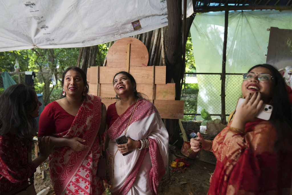 Devotees react upon seeing the idols of the Hindu goddess Durga as they arrive to take them to their place of worship ahead of the Durga Puja festival in New Delhi, India, Sunday, Sept. 21, 2025. (AP Photo/Manish Swarup)