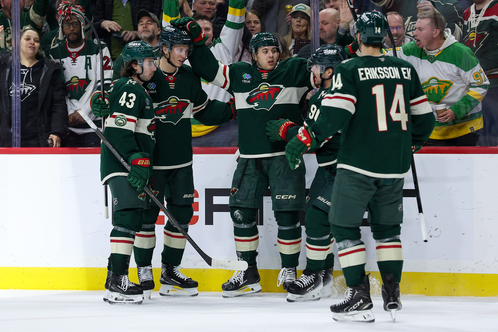 Minnesota Wild defenseman Brock Faber, center, celebrates with teammates after his goal during the third period of an NHL hockey game against the Montréal Canadiens, Monday, Feb. 2, 2026, in St. Paul, Minn. (AP Photo/Matt Krohn)