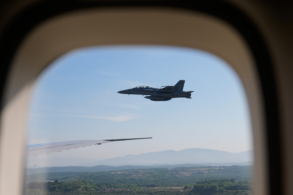 A Malaysian Air Force jet escorts Air Force One into Kuala Lumpur International Airport in Sepang, Malaysia, Sunday, Oct. 26, 2025. (AP Photo/Mark Schiefelbein)