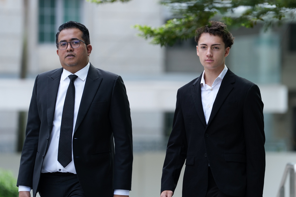 Didier Gaspard Owen Maximilien, right, walks with his lawyers as he arrives at the State Courts building in Singapore, Thursday, Jul. 30, 2026. (AP Photo/David Hu)