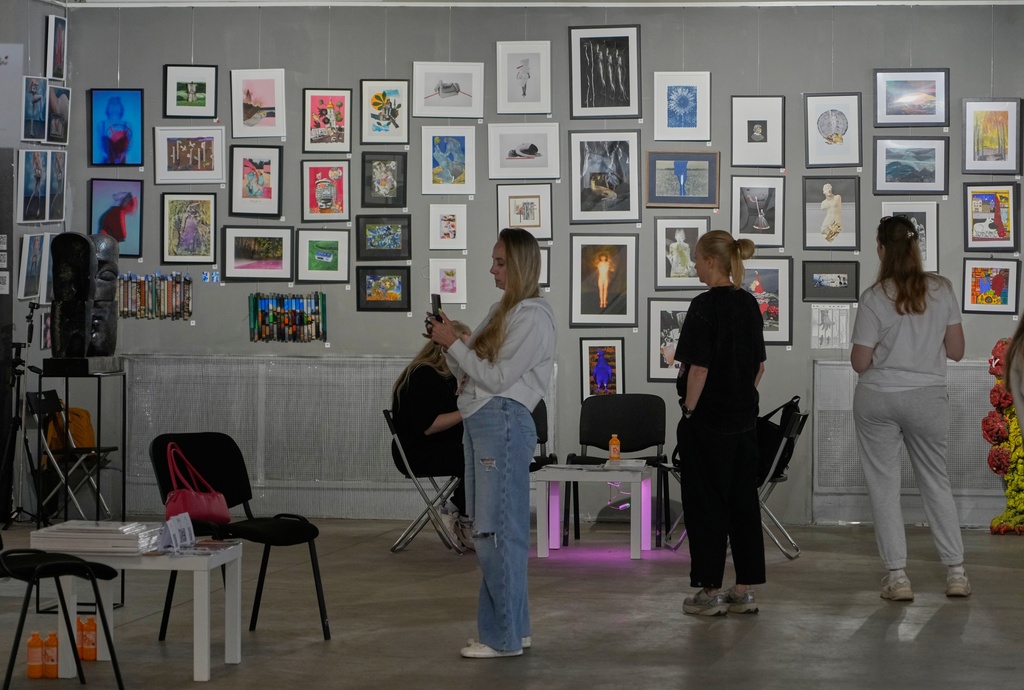 Visitors look at paintings by Ukrainian artists at the Art Kyiv 2026 Festival at the Art Ukraine Gallery in Kyiv, Ukraine, Friday, May 8, 2026. (AP Photo/Efrem Lukatsky)