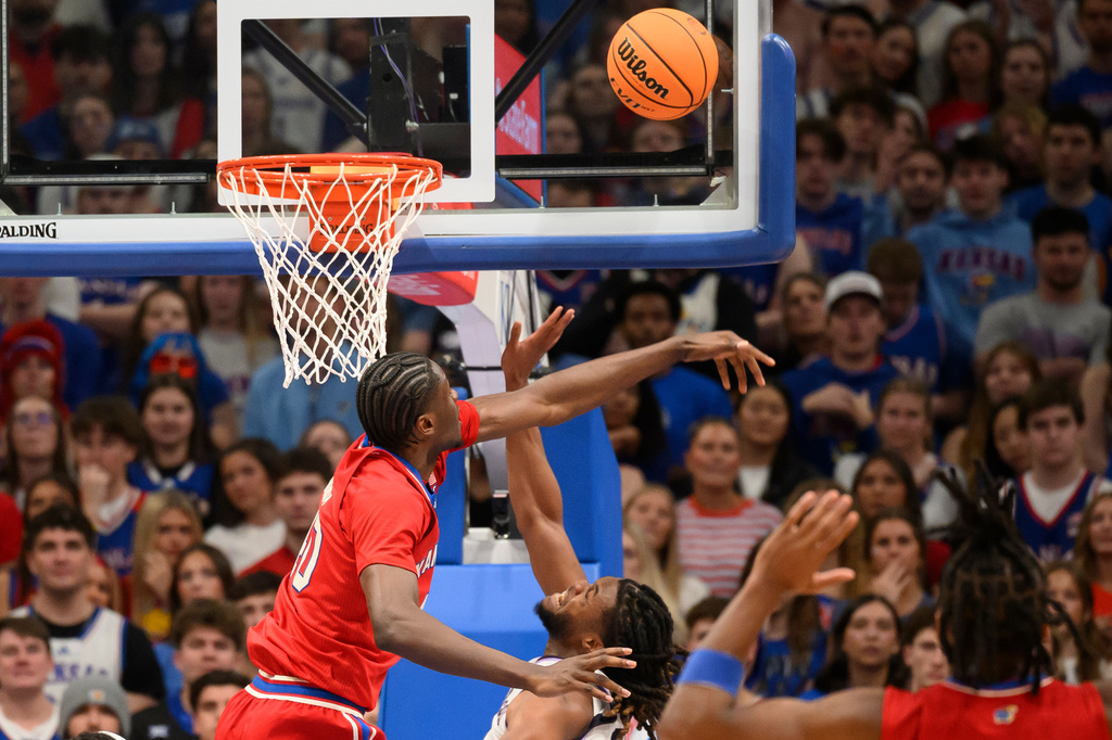 Kansas forward Flory Bidunga, left, blocks a shot by Kansas State forward Khamari McGriff, right, during the first half of an NCAA college basketball game in Lawrence, Kan., Saturday, March 7, 2026. (AP Photo/Reed Hoffmann)