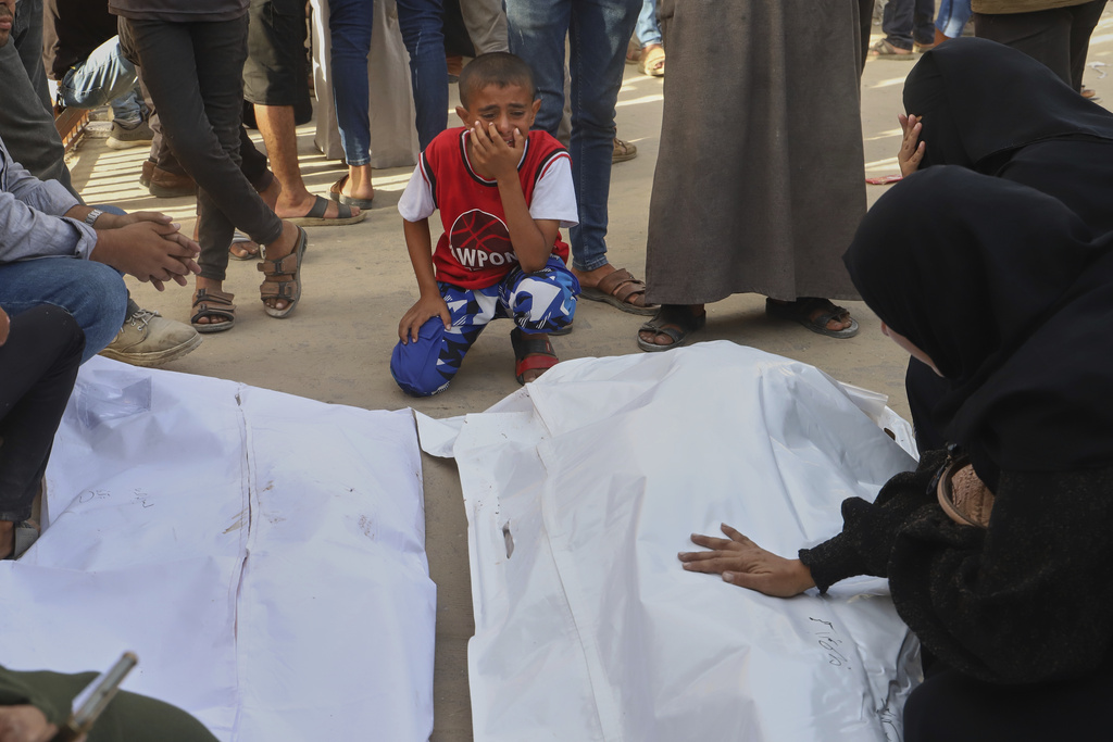 A Palestinian boy mourns over the bodies of his uncle, Mohammad Harb and his cousin Leen Harb, who were killed in an Israeli airstrike, during their funeral at Nasser Hospital, in Khan Younis, in the southern Gaza Strip, Tuesday, Aug. 19, 2025. (AP Photo/Mariam Dagga)
