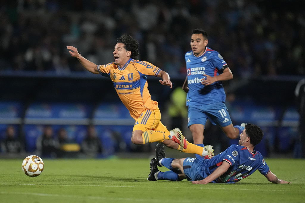 Cruz Azul's Ignacio Rivero tackles Tigres' Diego Lainez during a Mexican soccer league semifinal first leg match in Mexico City, Wednesday, Dec. 3, 2025. (AP Photo/Eduardo Verdugo)