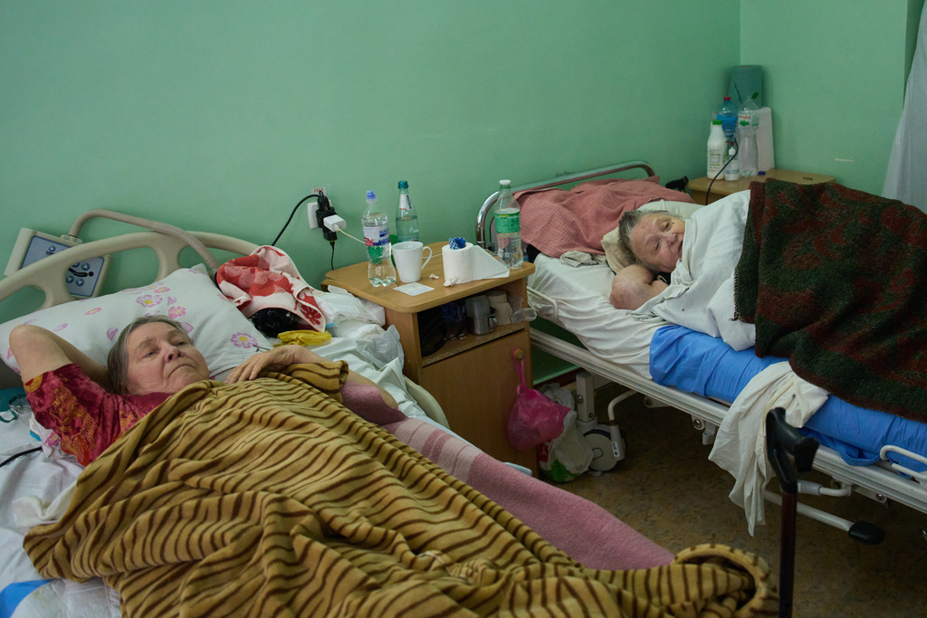 Nataliia Naumova, 70, right, recovers after a Shahed drone blasted her left leg at one of the city main hospitals treating drone victims in the frontline city of Kherson, Southern Ukraine, Monday, Nov. 3, 2025. (AP Photo/Efrem Lukatsky)
