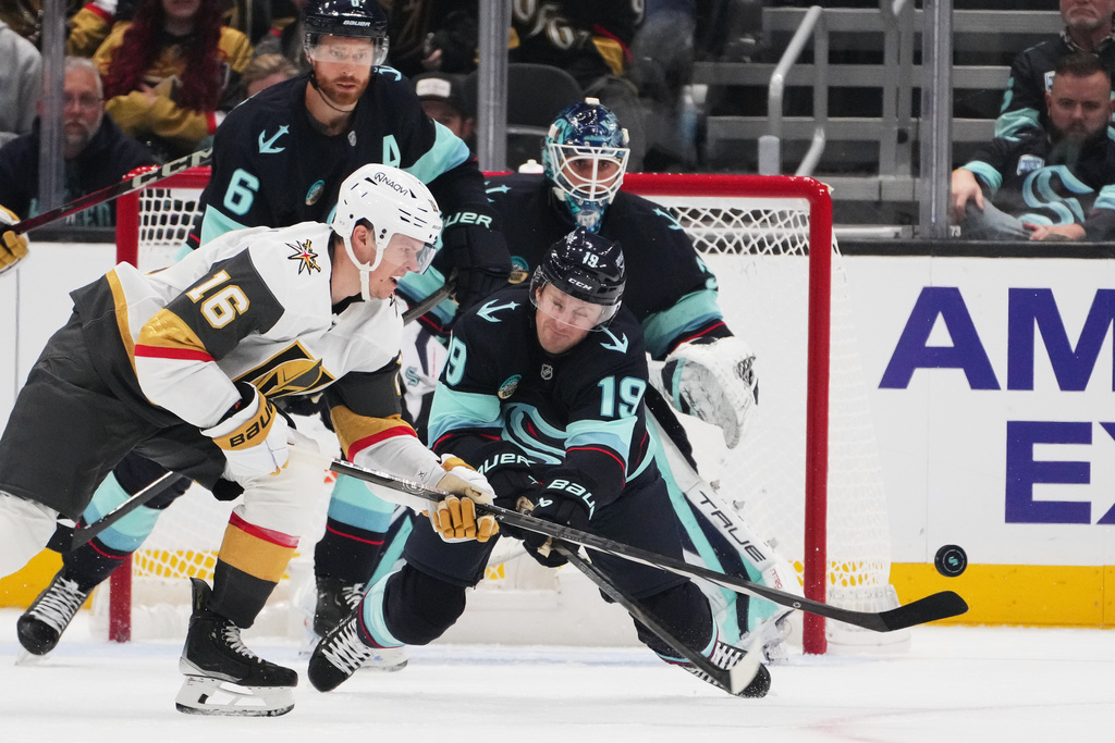 Seattle Kraken left wing Jared McCann (19) defends against Vegas Golden Knights right wing Pavel Dorofeyev (16) during the third period of an NHL hockey game Saturday, Oct. 11, 2025, in Seattle. (AP Photo/Lindsey Wasson)