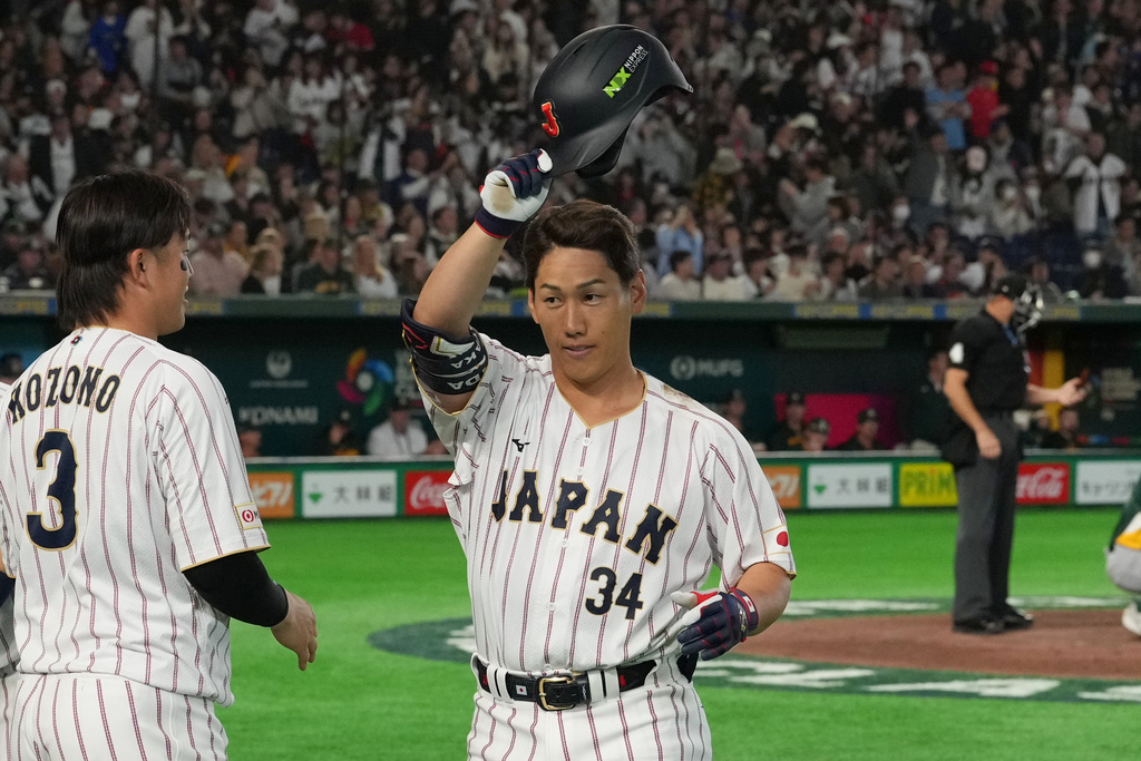 Japan's Masataka Yoshida, center, reacts after hitting two-run home run during the seventh inning of a World Baseball Classic game between Japan and Australia on Sunday, March 8, 2026 in Tokyo. (AP Photo/Hiro Komae)