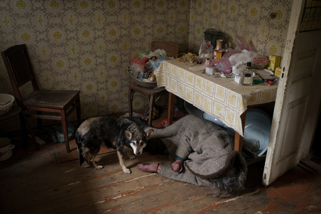 FILE - A dog stands next to the body of an elderly woman killed inside a home in Bucha on the outskirts of Kyiv, Ukraine, Tuesday, April 5, 2022. (AP Photo/Felipe Dana, File)
