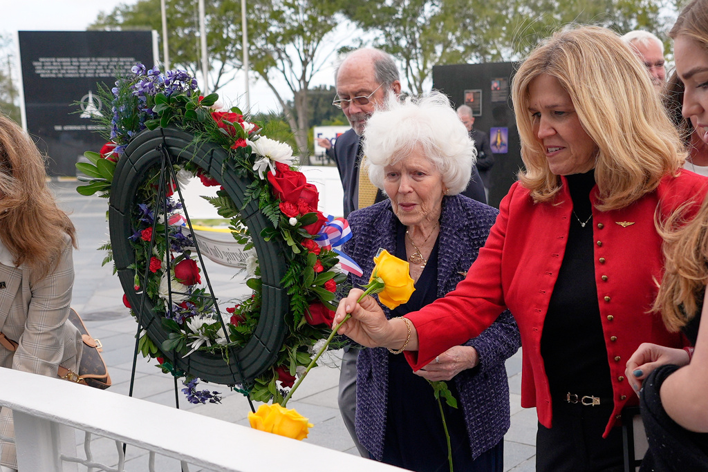 Jane Smith-Wolcott, center, widow of Challenger pilot Michael Smith and daughter Alison Smith Balch put flowers on a memorial during NASA's Day of Remembrance for the 40th Anniversary of the Challenger tragedy at the Kennedy Space Center Visitor Complex in Cape Canaveral, Fla., Thursday, Jan. 22, 2026. (AP Photo/John Raoux)