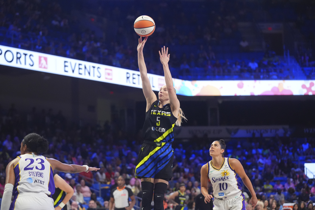 Dallas Wings guard Paige Bueckers (5) shoots against Los Angeles Sparks defenders Kelsey Plum (10) and Azura Stevens (23) during the first half of a WNBA basketball game in Arlington, Texas, Friday, Aug. 15, 2025. (AP Photo/LM Otero)