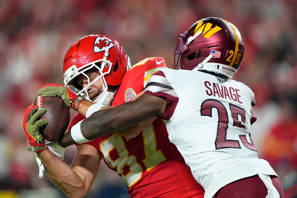 Kansas City Chiefs tight end Travis Kelce catches a touchdown pass as Washington Commanders safety Darnell Savage (25) defends during the second half of an NFL football game Monday, Oct. 27, 2025, in Kansas City, Mo. (AP Photo/Charlie Riedel)