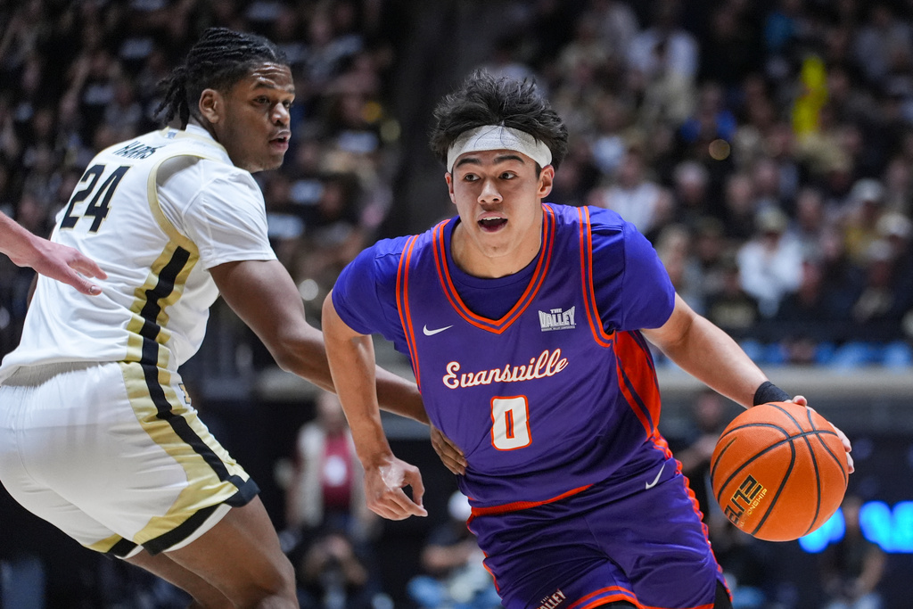 Evansville guard Bryce Quinet (0) drives on Purdue guard Gicarri Harris (24) during the first half of an NCAA college basketball game in West Lafayette, Ind., Tuesday, Nov. 4, 2025. (AP Photo/Michael Conroy)