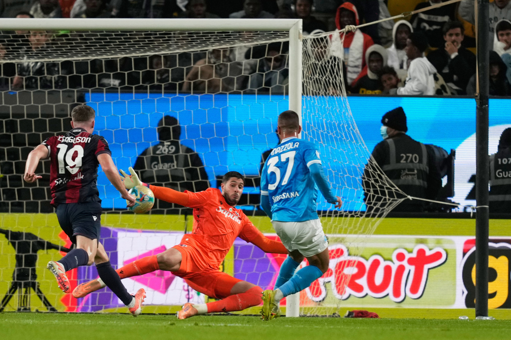 Bologna's goalkeeper Federico Ravaglia, center, saves the ball during the Italian Super Cup final soccer match between Napoli and Bologna in Riyadh, Saudi Arabia, Monday, Dec. 22, 2025. (AP Photo/Altaf Qadri)