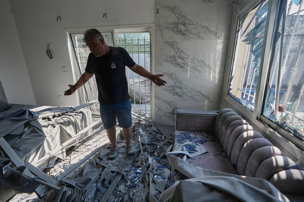 A man checks his damaged bedroom near the site where an Israeli airstrike hit and destroyed a house in Ansar village, southern Lebanon, Saturday, Aug. 15, 2026. (AP Photo/Mohammed Zaatari)