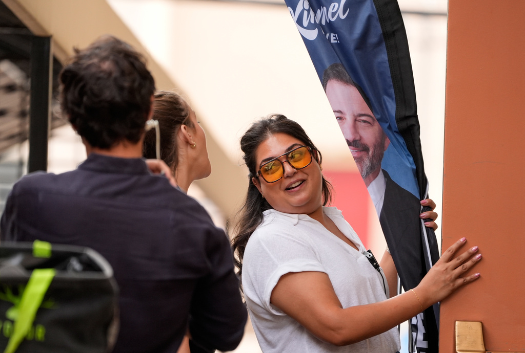 A "Jimmy Kimmel Live!" crew member brings in a banner sporting his likeness before a taping of the show at the show's studio on Hollywood Blvd., on Tuesday, Sept. 23, 2025, in Los Angeles. (AP Photo/Chris Pizzello)