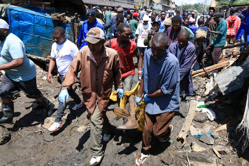 Volunteers carry the body of a man recovered after heavy rains in Nairobi, Kenya, Saturday, March 7, 2026. (AP Photo/Andrew Kasuku)
