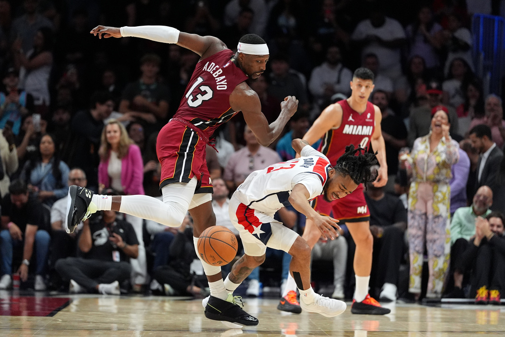 Miami Heat center Bam Adebayo clashes with Washington Wizards guard Sharife Cooper during the second half of an NBA basketball game, Tuesday, March 10, 2026, in Miami. (AP Photo/Rebecca Blackwell)