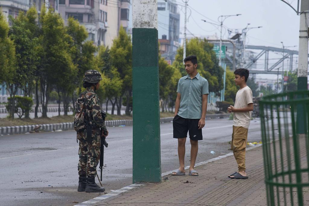 A Nepalese army person checks and question civilians at a checkpoint in Kathmandu, Nepal, Wednesday, Sept. 10, 2025. (AP Photo/Niranjan Shrestha)