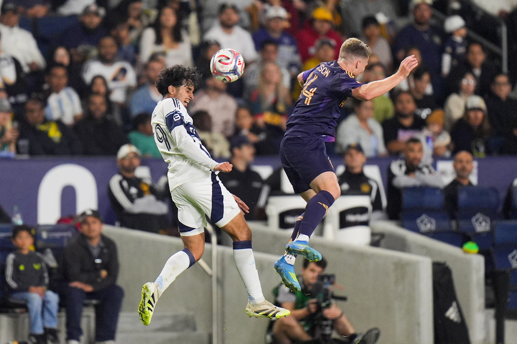 Vancouver Whitecaps midfielder Jeevan Badwal (59) heads the ball behind Los Angeles Galaxy defender John Nelson (14) during the first half of an MLS soccer match Saturday, May 2, 2026, in Carson, Calif. (AP Photo/Jae C. Hong)