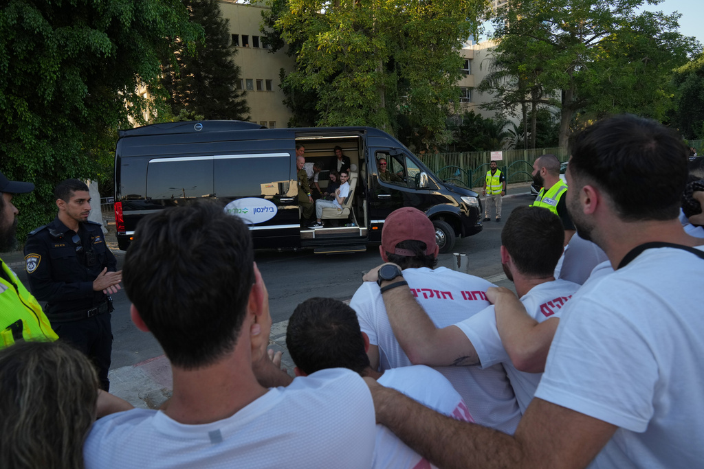 Freed Israeli hostage Evyatar David gestures from a van as he arrives at Beilinson hospital in Petah Tikva, Israel, after he was released from Hamas captivity in the Gaza Stripl, Monday, Oct. 13, 2025. (AP Photo/Francisco Seco)
