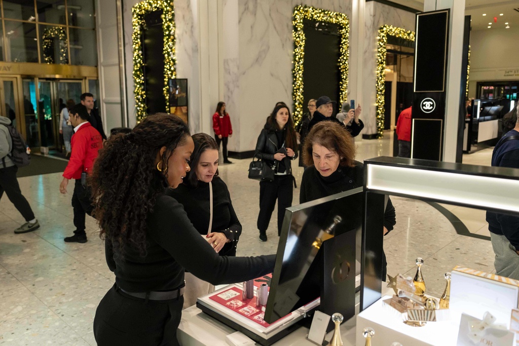 Associated Press reporter Anne D'Innocenzio helps a customer out at Macy's flagship store, Friday, Nov. 21, 2025, in New York. (AP Photo/Yuki Iwamura)