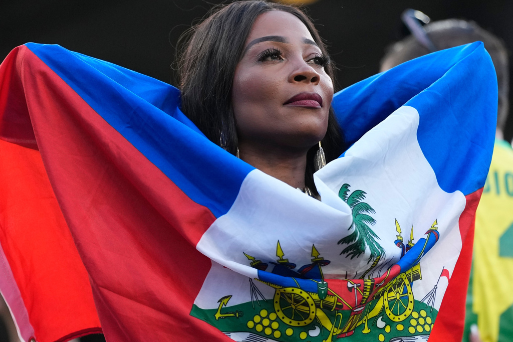 A Haiti fan, wrapped in national flag, looks on prior to the World Cup Group C soccer match between Brazil and Haiti in Philadelphia, Friday, June 19, 2026. (AP Photo/Matt Slocum)