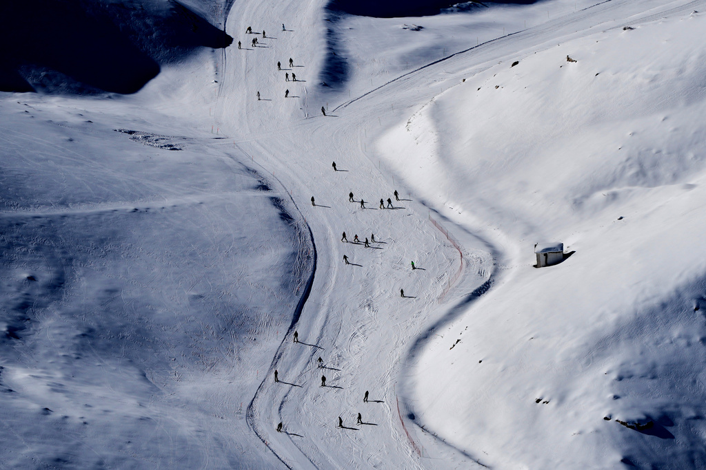 Skiers cast long shadows as they glide down a slope at the Mzaar-Kfardebian ski resort northeast of Beirut, Lebanon, Saturday, Jan. 3, 2026. (AP Photo/Hassan Ammar)