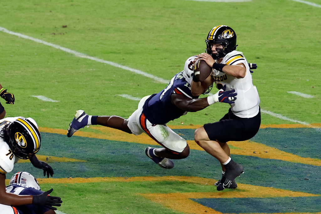 Missouri quarterback Beau Pribula (9) is sacked by Auburn linebacker Jamonta Waller (11) during the second half of an NCAA college football game, Saturday, Oct. 18, 2025, in Auburn, Ala. (AP Photo/Butch Dill)
