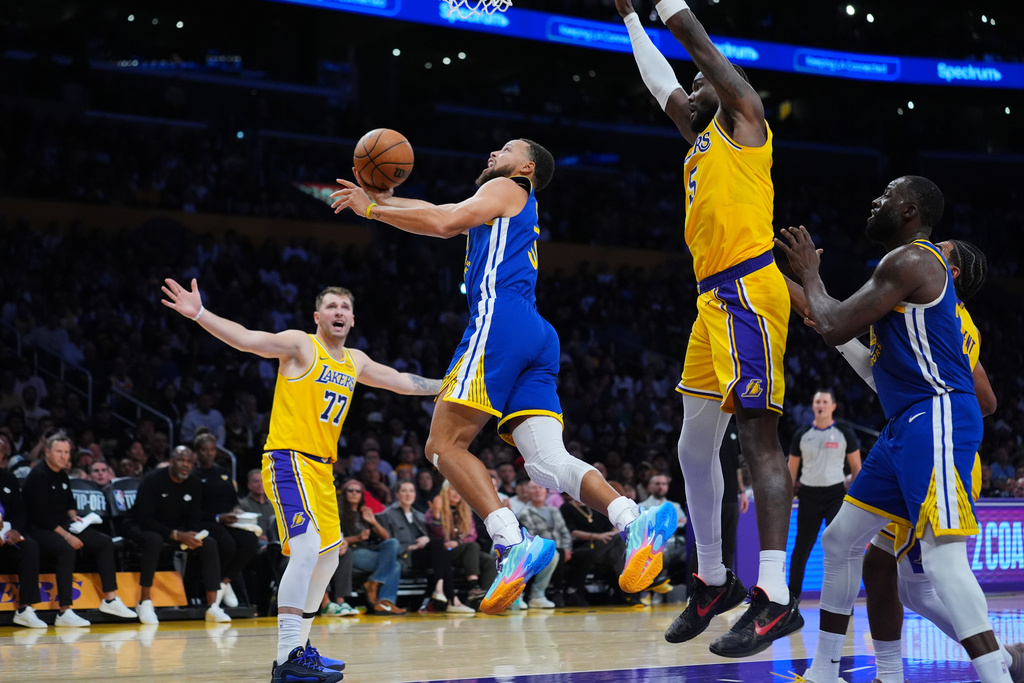 Golden State Warriors guard Stephen Curry drives to the basket during the first half of an NBA basketball game against the Los Angeles Lakers, Tuesday, Oct. 21, 2025, in Los Angeles. (AP Photo/Ethan Swope)
