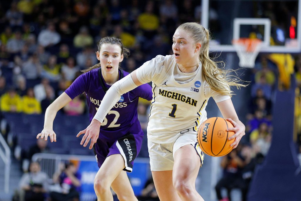 Michigan guard Olivia Olson, right, drives against Holy Cross guard Kendall Eddy, left, during the first half in the first round of the NCAA college basketball tournament Friday, March 20, 2026, in Ann Arbor, Mich. (AP Photo/Al Goldis)