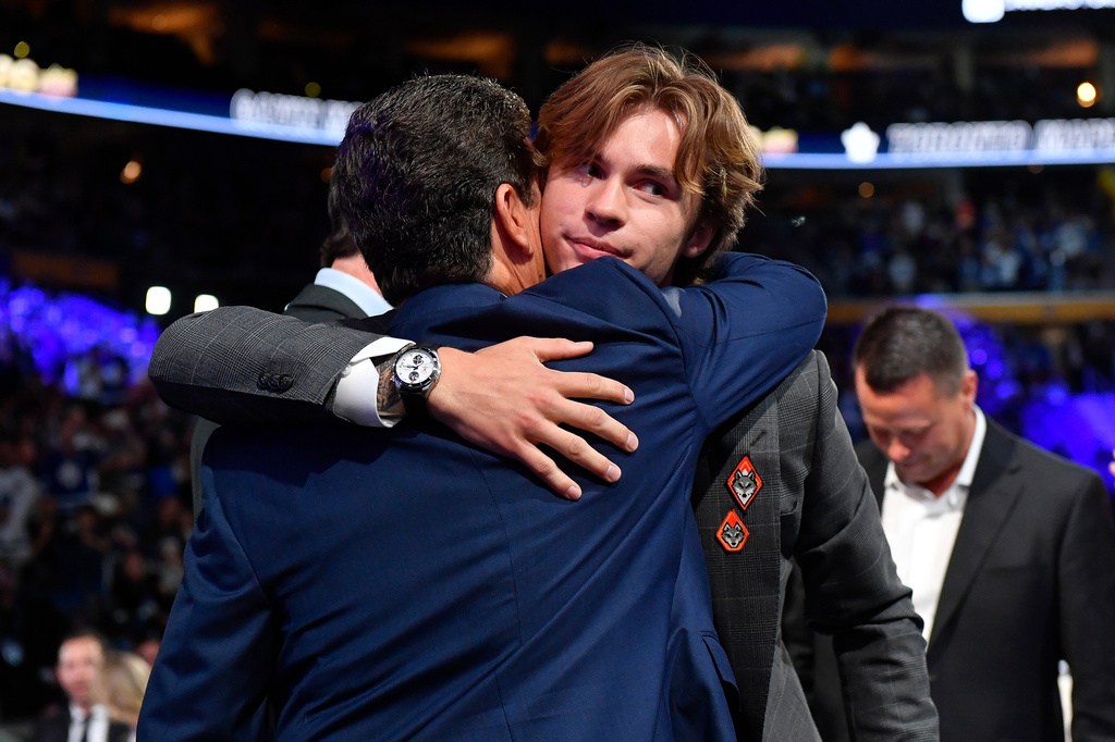 Gavin McKenna, center right, is congratulated after being drafted by the Toronto Maple Leafs during the NHL hockey draft Friday, June 26, 2026, in Buffalo, N.Y. (AP Photo/Adrian Kraus)