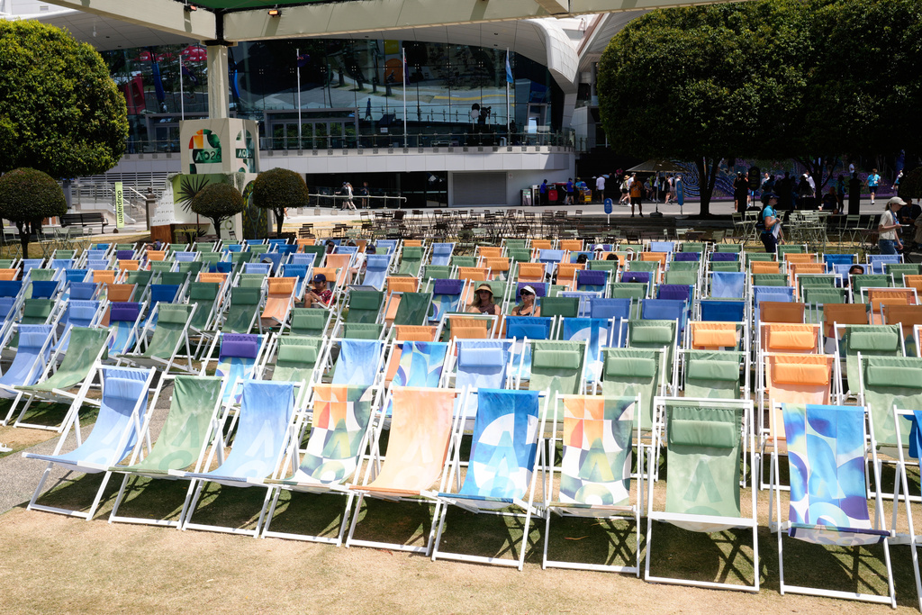Fans sit in the shade as they watch quarterfinal matches on a video screen at the Australian Open tennis championship in Melbourne, Australia, Tuesday, Jan. 27, 2026. (AP Photo/Dar Yasin)