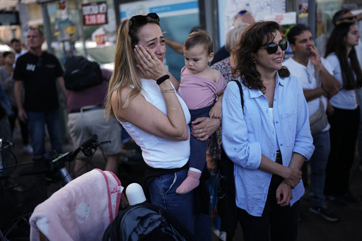 People react as they gather to watch a live broadcast of Israeli hostages released from Gaza at a plaza known as hostages square in Tel Aviv, Israel, Monday, Oct. 13, 2025. The release took place as part of a cease-fire agreement between Israel and Hamas. (AP Photo/Oded Balilty) People react as they gather to watch a live broadcast of Israeli hostages released from Gaza at a plaza known as hostages square in Tel Aviv, Israel, Monday, Oct. 13, 2025. The release took place as part of a cease-fire agreement between Israel and Hamas. (AP Photo/Oded Balilty)